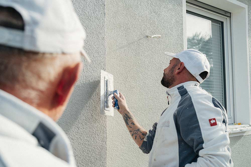 Stuckateurmeister Sven Holterhöfer verputzt eine Außenwand